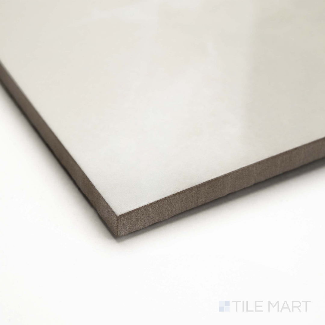 Soller Onyx Marfil 24x48 polished porcelain tile photographed from a corner, showing warm beige tones, polished finish, and full edge clarity.