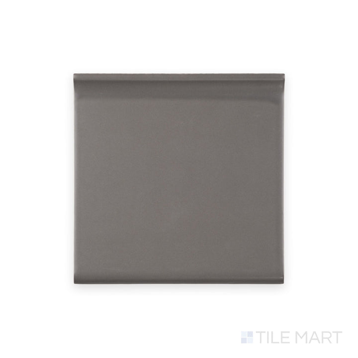 Close-up of dark gray sanitary cove base 6x6 matte ceramic tile revealing smooth curved transition