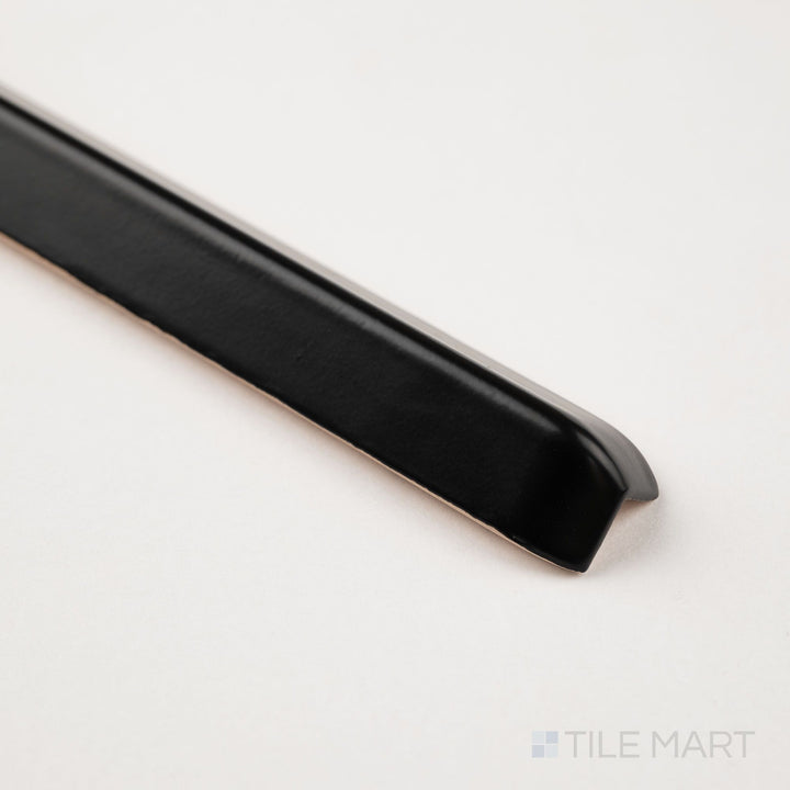 Corner detail of black sanitary cove base 1x6 outside corner matte ceramic trim showcasing curved exterior edge