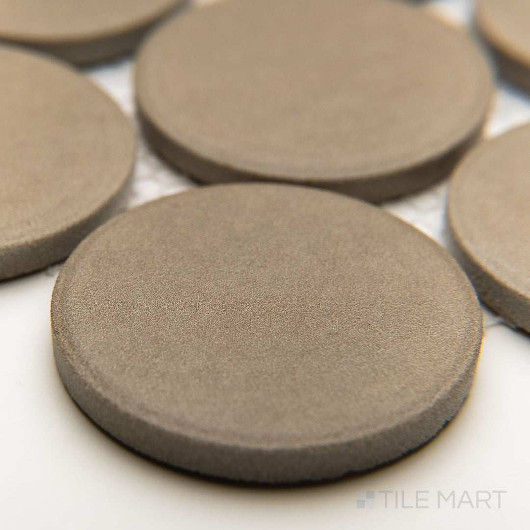 Angled corner perspective of Amuri Grigio 2" round mosaic tiles featuring a soft matte finish and circular pattern.