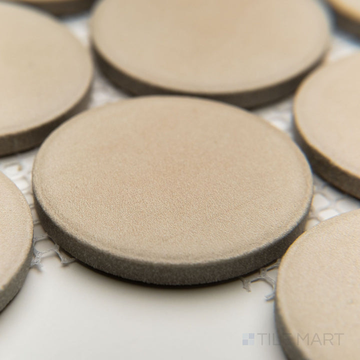 Slanted corner view highlighting Amuri Avorio 2" round porcelain tiles in a warm ivory hue with a matte finish.