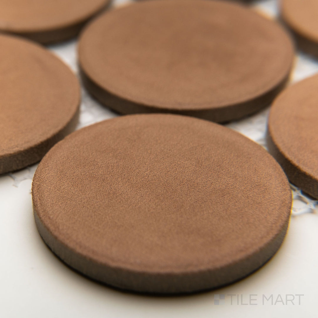 Perspective angle capturing the rounded design of Amuri Cotto 2" matte mosaic tiles with soft terracotta shading.