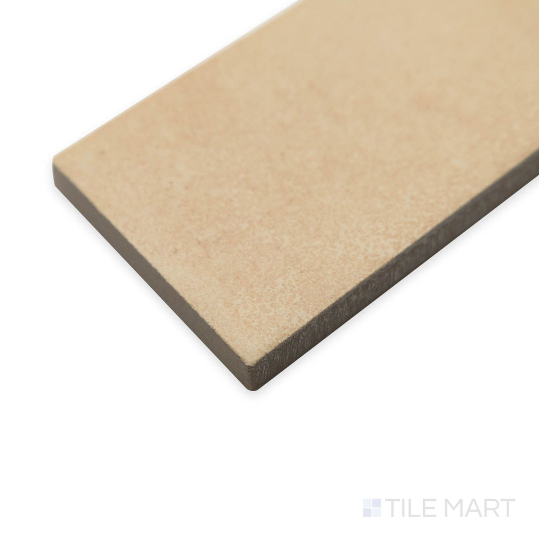 Angled display of Amuri Brick Biscotto 2x12 porcelain tiles with light caramel tones and sleek matte texture.