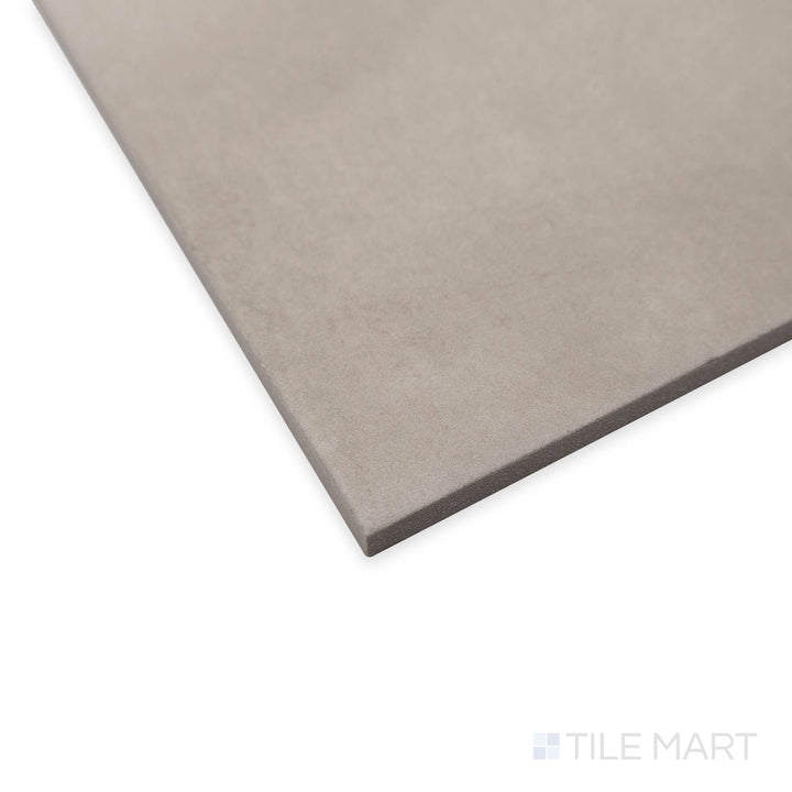 Perspective view of Amuri Grigio 8x8 porcelain tile in a neutral gray shade with soft surface reflections.