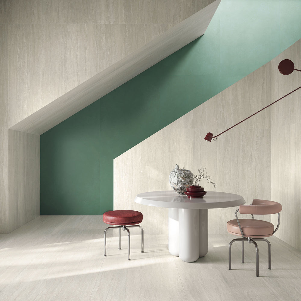 Modern dining area with a white marble table and pink stools set against green and beige walls, enhanced by Dorset Vein Cut Bianco 12x24 Matte Porcelain Tile for a refined stone effect.