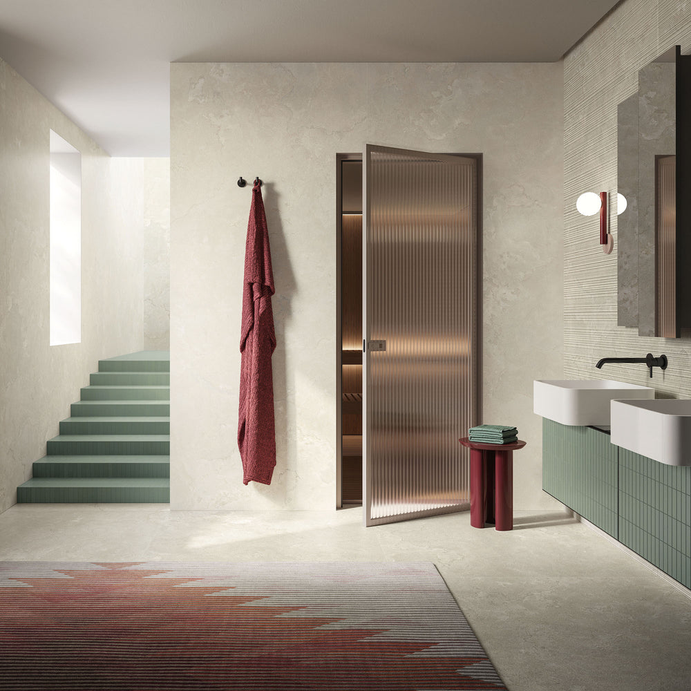 Modern bathroom with a metallic door, towel, and sink, showcasing Dorset Cross Cut Bianco 48x48 Matte Porcelain Tile for a subtle, clean stone aesthetic.