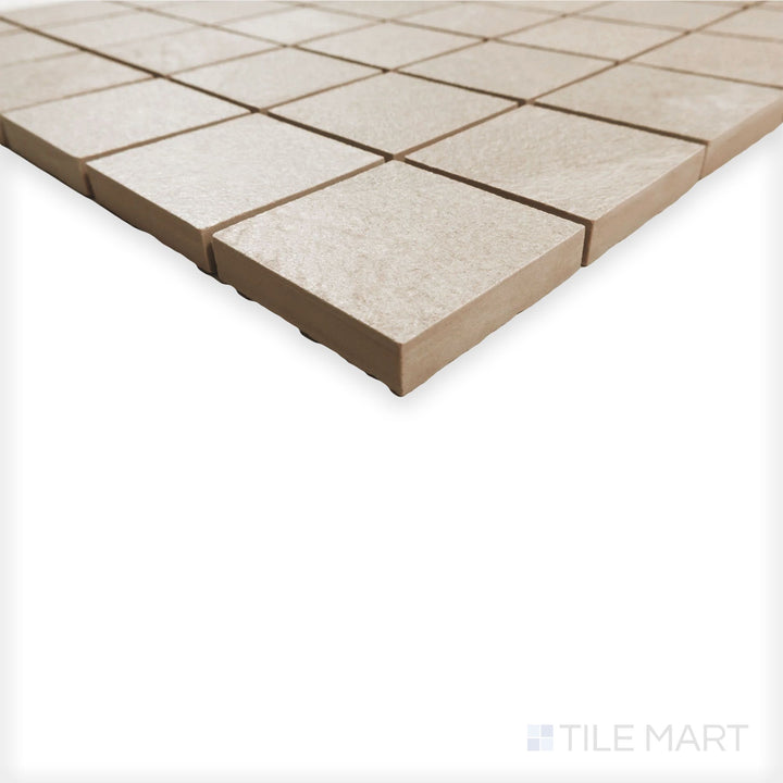 Angled shot of Hurricane Sand 2" square mosaic showing warm beige tiles and subtle tone shifts across the grid.
