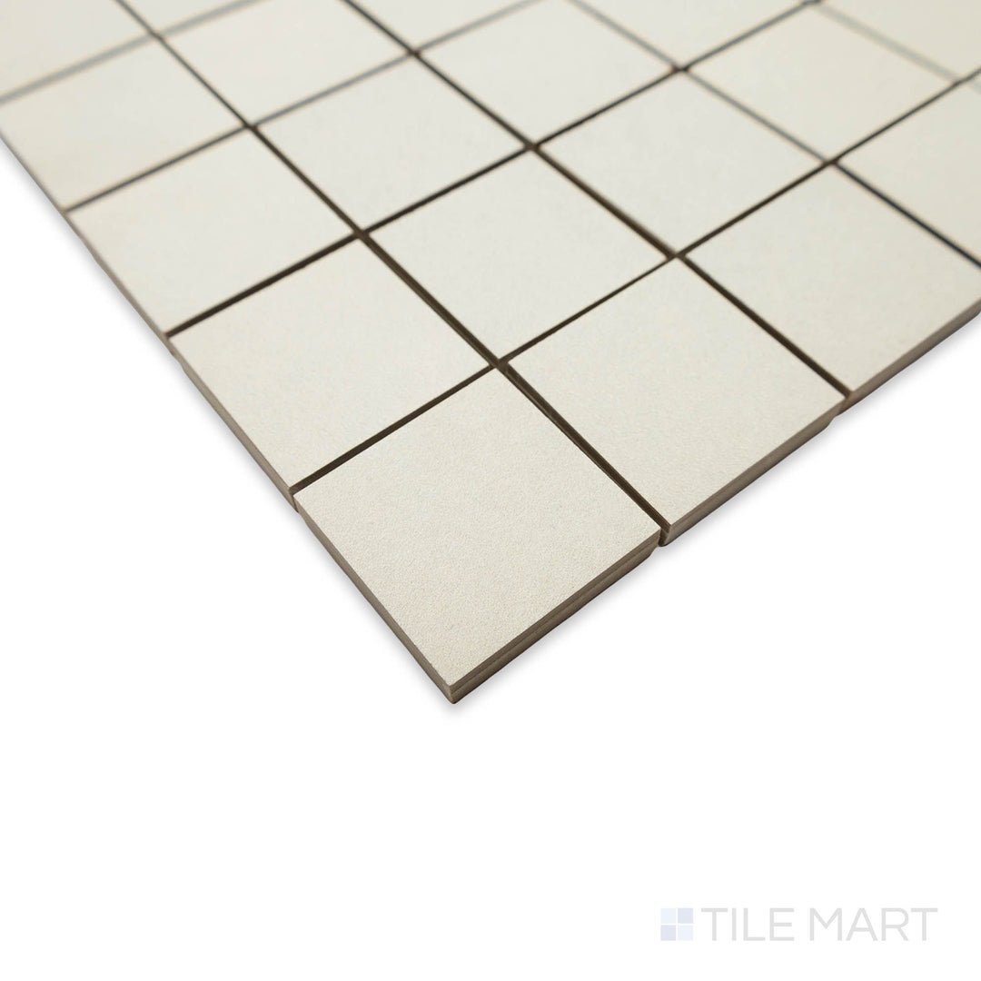 Oblique angle of Nuances Bianco 2" square mosaic tiles showing refined edges and crisp white tone.