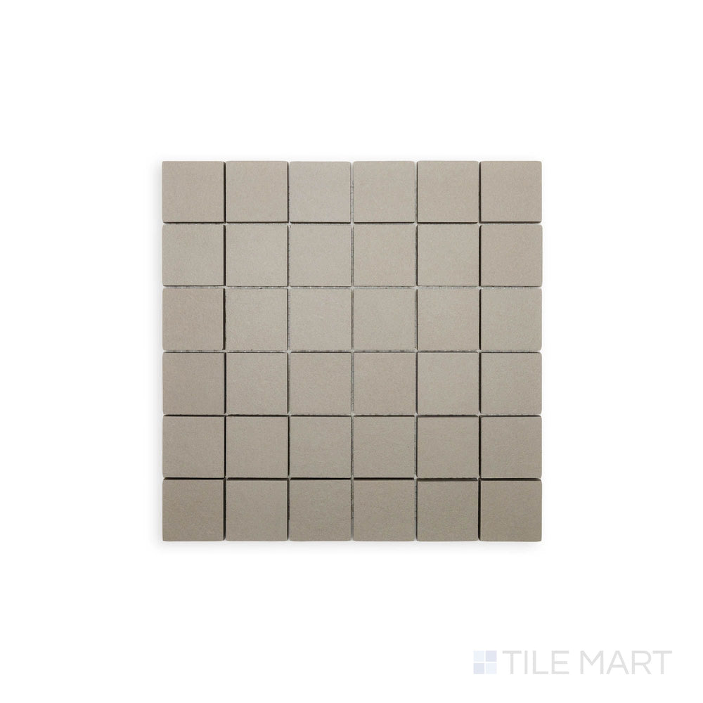 Flat-lay photograph of Nuances Tortora 2" Square Matte Porcelain Mosaic, showcasing warm taupe tones in a small-scale mosaic design for detailed surface applications.