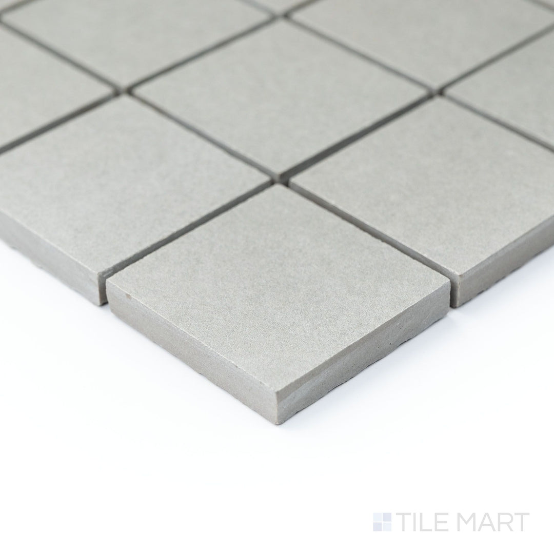 Corner shot of Nuances Grigio 2" square mosaic tiles displaying soft gray hues and matte surface in a refined layout.