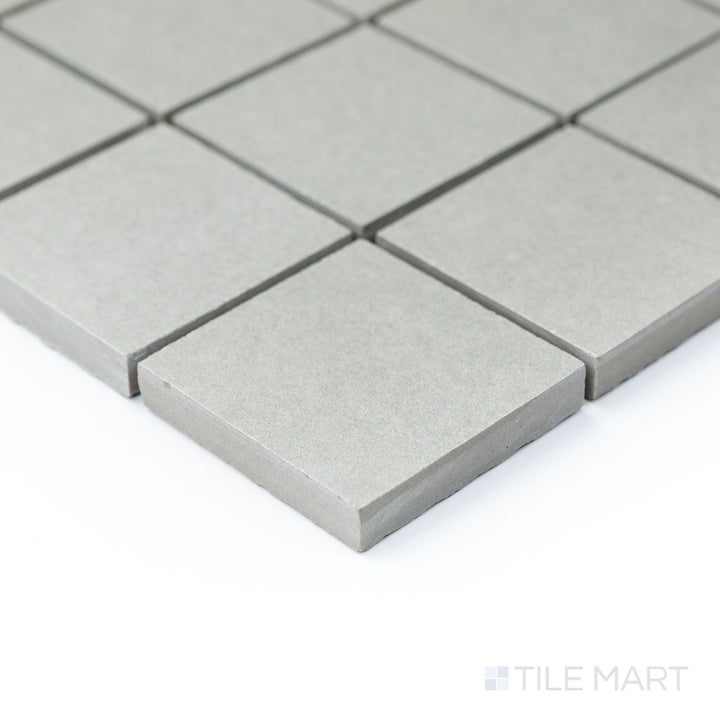 Corner shot of Nuances Grigio 2" square mosaic tiles displaying soft gray hues and matte surface in a refined layout.