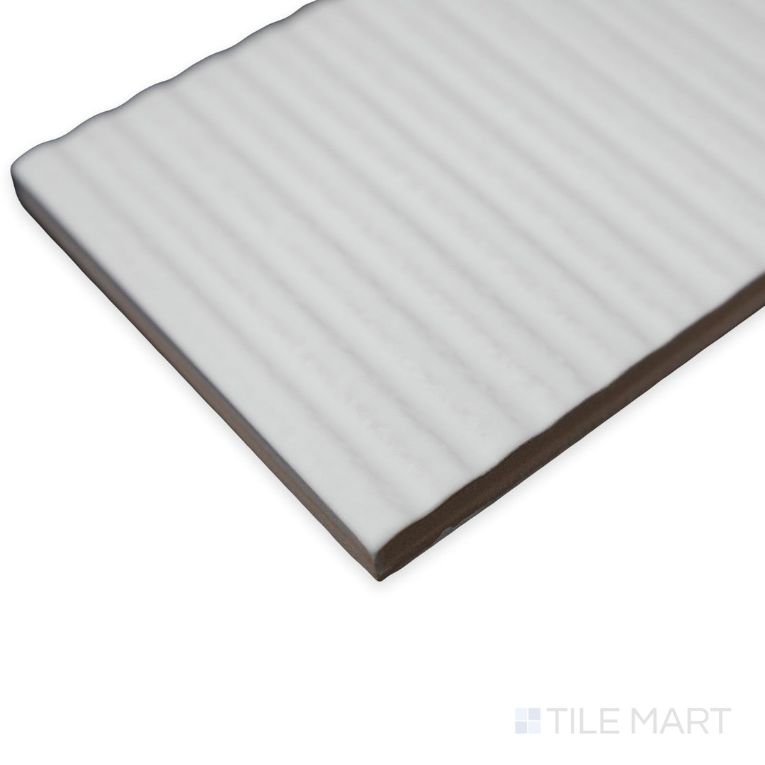 Side angle of Van Decor Blanco tile revealing a subtle decorative texture layered over a white ceramic base.