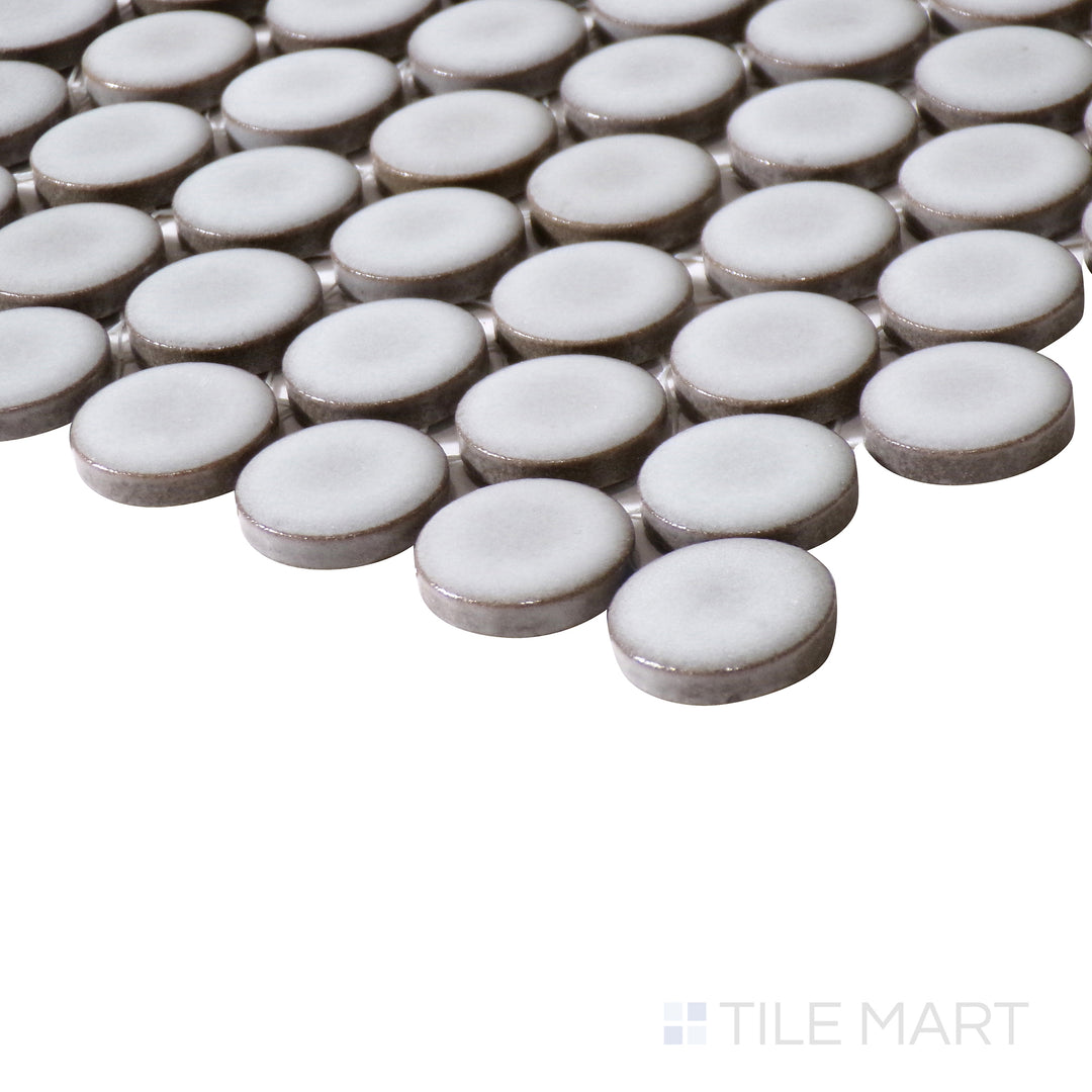 Angled close-up of 360° Dove Grey 3/4" penny round gloss glazed porcelain mosaic, showcasing its soft grey tone, glossy texture, and the precise way its edges meet at the corner.