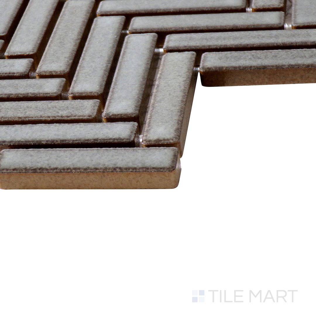 Corner shot of 90° Gray Haze Herringbone gloss glazed porcelain mosaic, highlighting its intricate herringbone layout, sleek reflective surface, and precisely aligned edges.