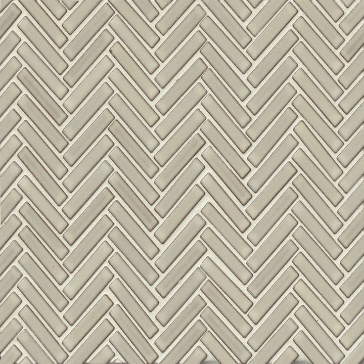 This top-down perspective emphasizes the warm neutral tones of the 90° Putty Herringbone mosaic, complemented by its glossy sheen and intricate layout.