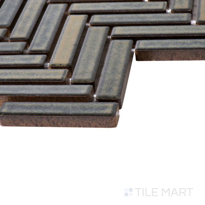 Angled view of 90° Shadow Herringbone gloss glazed porcelain mosaic, drawing attention to its deep grey undertones, geometric pattern, and polished surface forming a crisp corner.