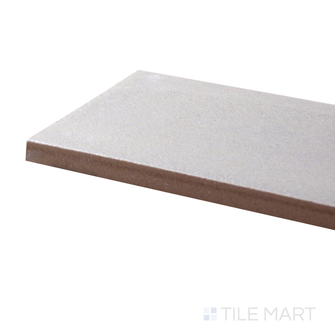 Corner perspective of Allora Grey 3x24 matte glazed porcelain tile, emphasizing its cool grey tone, soft matte texture, and how its long edges meet at a smooth angle.