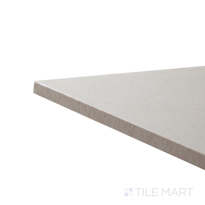 Corner shot of Allora Grey 7.375x12.75 matte glazed porcelain tile, featuring a muted grey hue, smooth texture, and the sharp intersection of its edges.