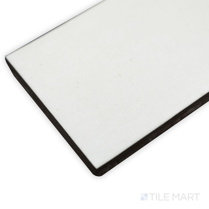 Corner close-up of Celine White 2.5x12 matte glazed porcelain tile, featuring its clean white finish, non-reflective matte surface, and precisely defined edge transition.