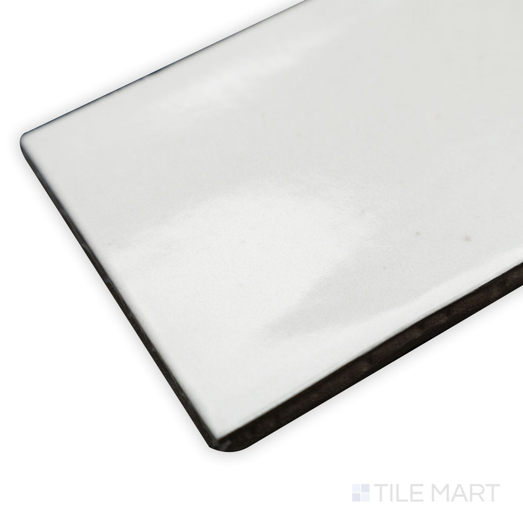 Side-angle view of Celine White 2.5x12 gloss glazed porcelain tile, emphasizing its glossy sheen, radiant white color, and smooth edge definition at the corner.