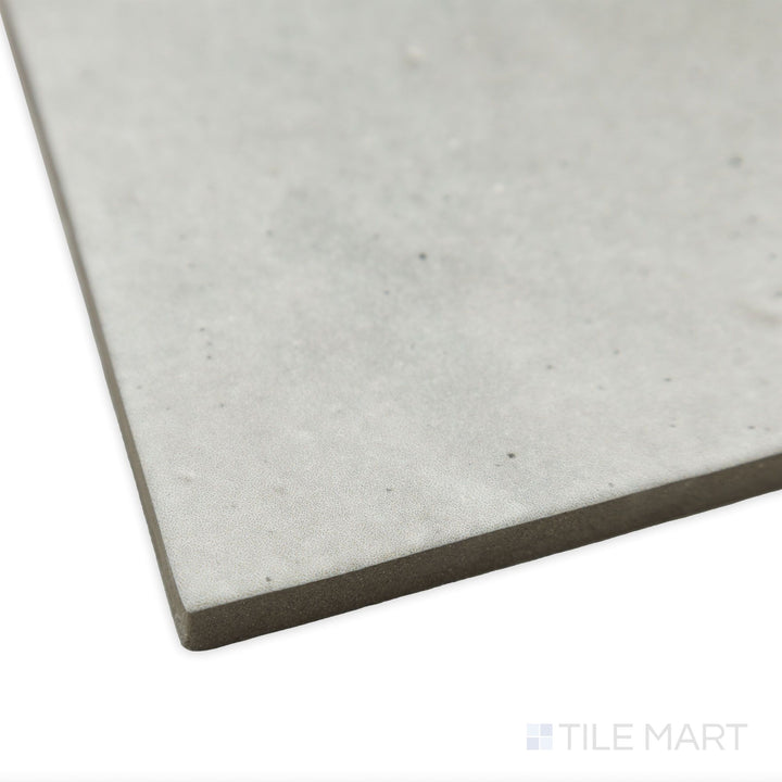 Angled perspective of Celine Greige 4x4 matte glazed porcelain tile, highlighting its neutral beige-grey hue, smooth matte texture, and precisely cut edges aligning at the corner.
