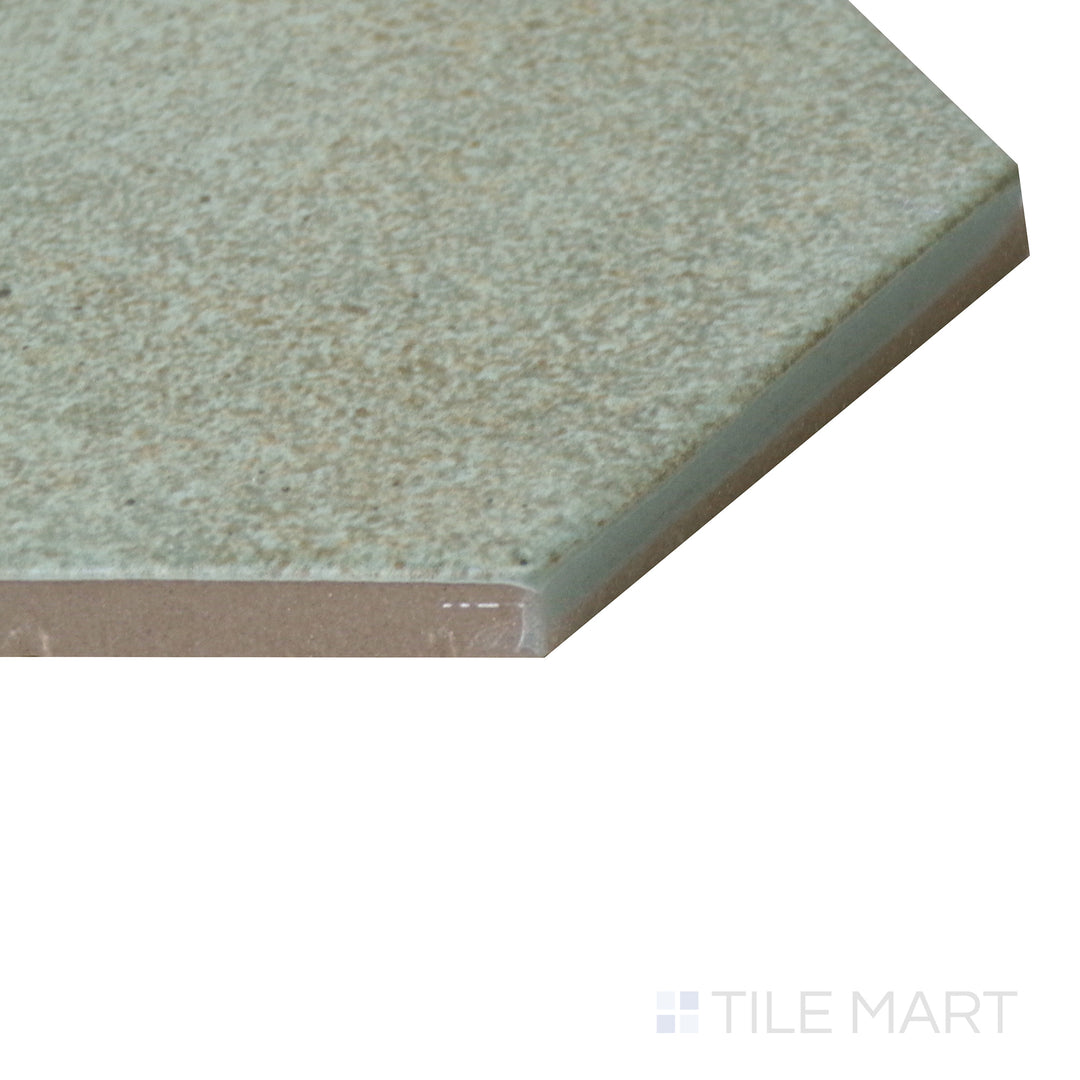 Angled close-up of Celine Sage 4" hex matte glazed porcelain tile, emphasizing its muted green tone, structured hexagonal layout, and precise corner formation.