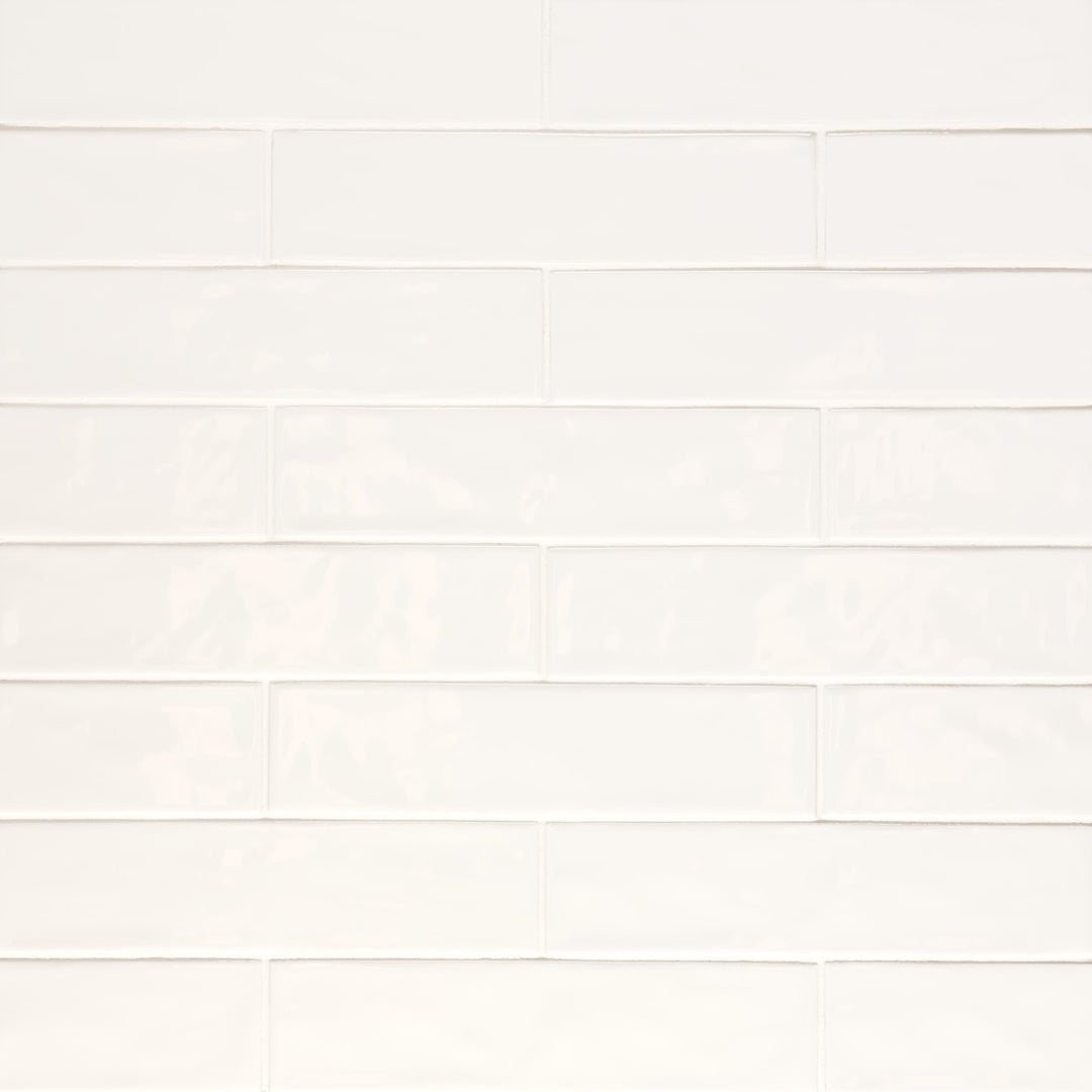 An overhead perspective of the Clara Ivory 2.75X11 glossy porcelain tile highlights its soft beige hue and reflective surface, giving a luminous finish that enhances brightness.