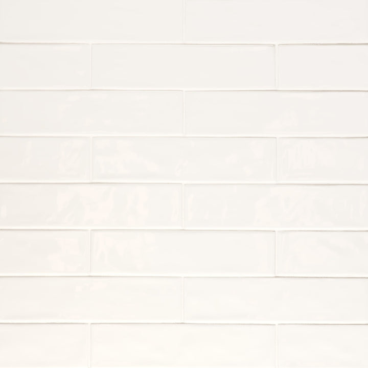 An overhead perspective of the Clara Ivory 2.75X11 glossy porcelain tile highlights its soft beige hue and reflective surface, giving a luminous finish that enhances brightness.