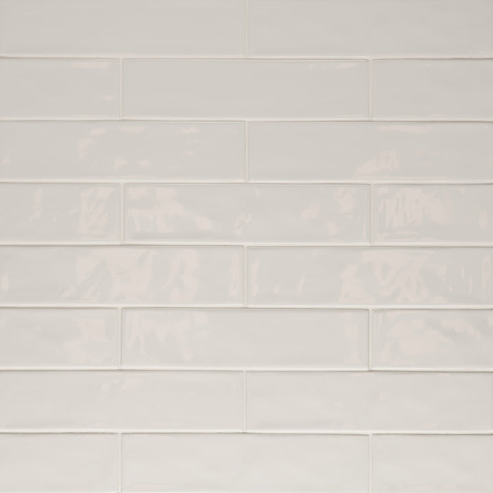 A top-down view of the Clara Grey 2.75X11 glossy porcelain tile reveals its smooth, cool gray tone and glassy finish, creating a modern yet timeless aesthetic.