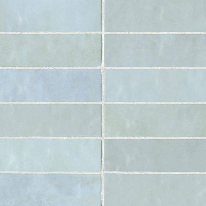 An aerial view of the Cloe Baby Blue 2.5X8 glossy ceramic tile highlights its delicate pastel blue and glass-like sheen, evoking a fresh and serene ambiance.