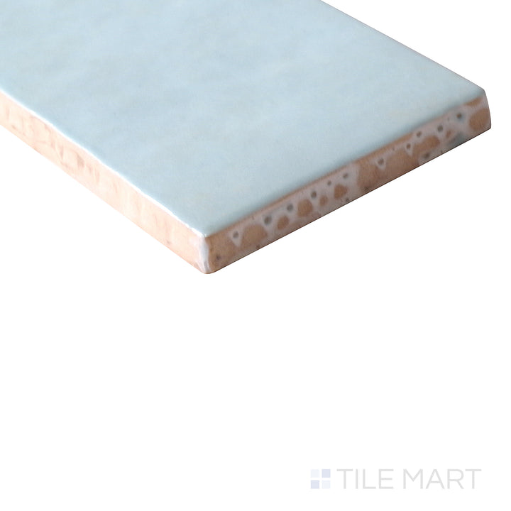 Corner shot of Cloe Baby Blue 2.5x8 gloss glazed ceramic tile, featuring a delicate pastel blue hue, sleek glossy surface, and precisely cut edges forming a seamless transition.
