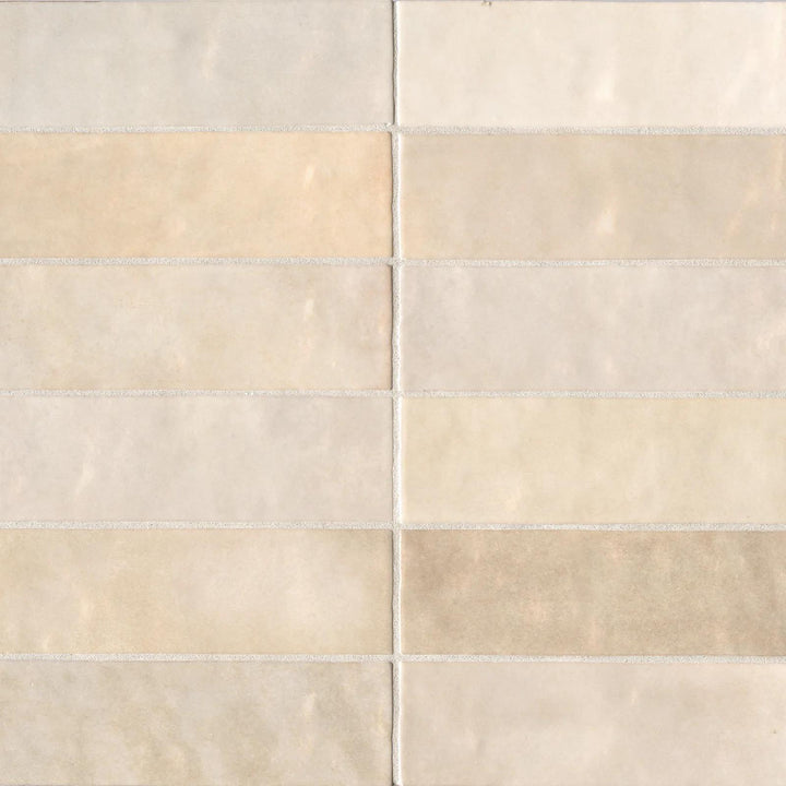 An overhead view of the Cloe Crème 2.5X8 glossy ceramic tile highlights its soft beige hue and mirror-like glaze, delivering warmth with a subtle shine.