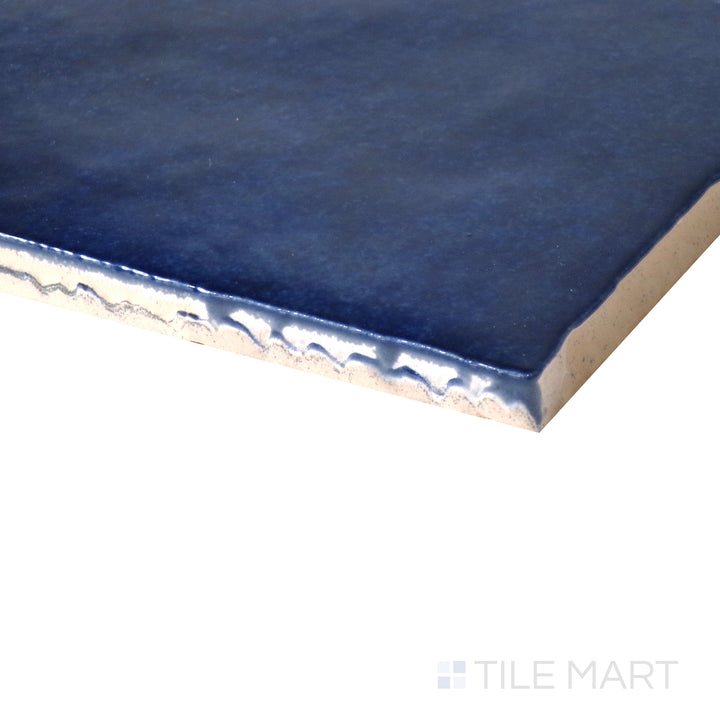 Side-angle perspective of Cloe Blue 5x5 gloss glazed ceramic tile, featuring a striking blue color, reflective finish, and smooth corner detailing.