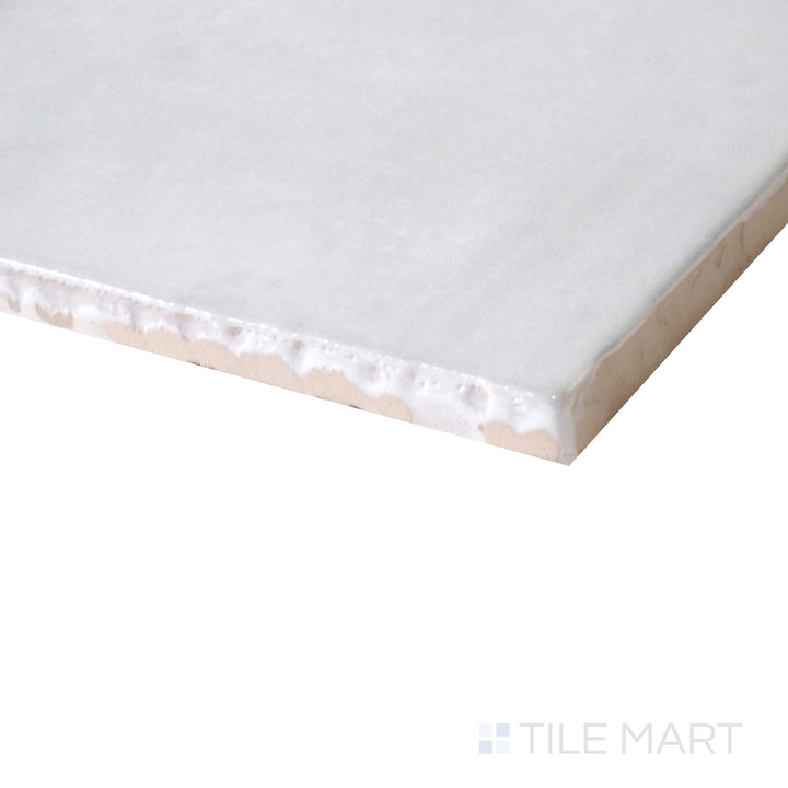 Corner shot of Cloe Grey 5x5 gloss glazed ceramic tile, featuring a soft grey shade, polished surface, and how the light enhances its smooth transition at the edges.