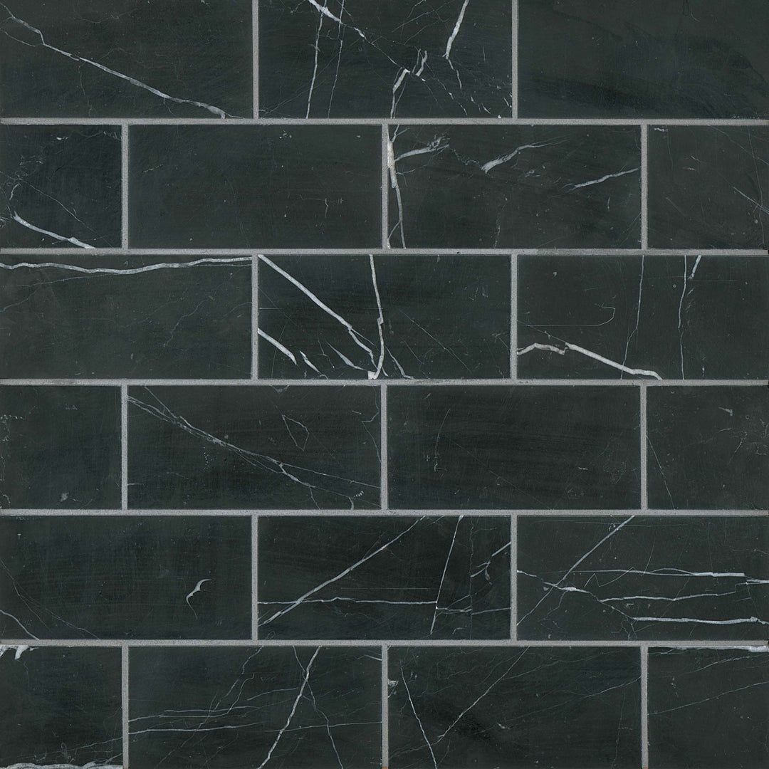 From a bird’s-eye perspective, the Ferrara Nero 3X6 honed marble tile showcases deep black hues with subtle white veining, enhancing any space with bold sophistication.