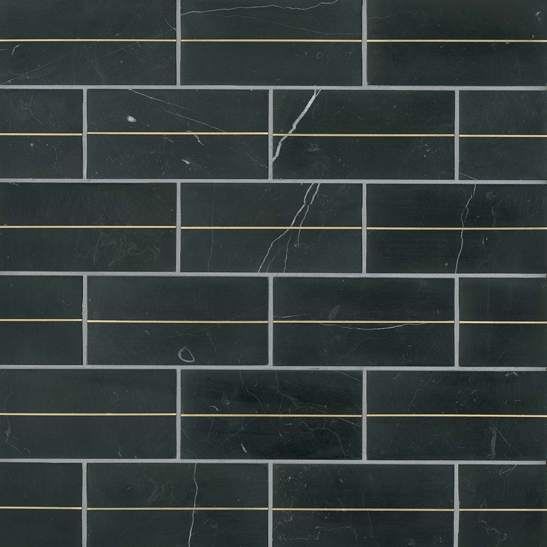 From a top-down angle, the Ferrara Nero Deco 3X6 honed marble tile showcases a bold black surface with contrasting brass inlays, delivering a striking and refined aesthetic.