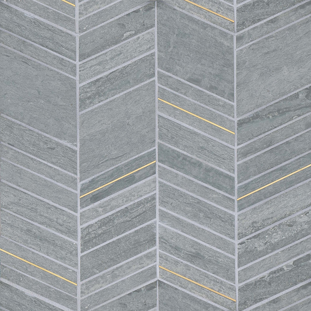 A top-down capture of the Ferrara Argento Chevron honed marble mosaic highlights its soft gray tones, gracefully interwoven with brass elements that create a dynamic, angular pattern.