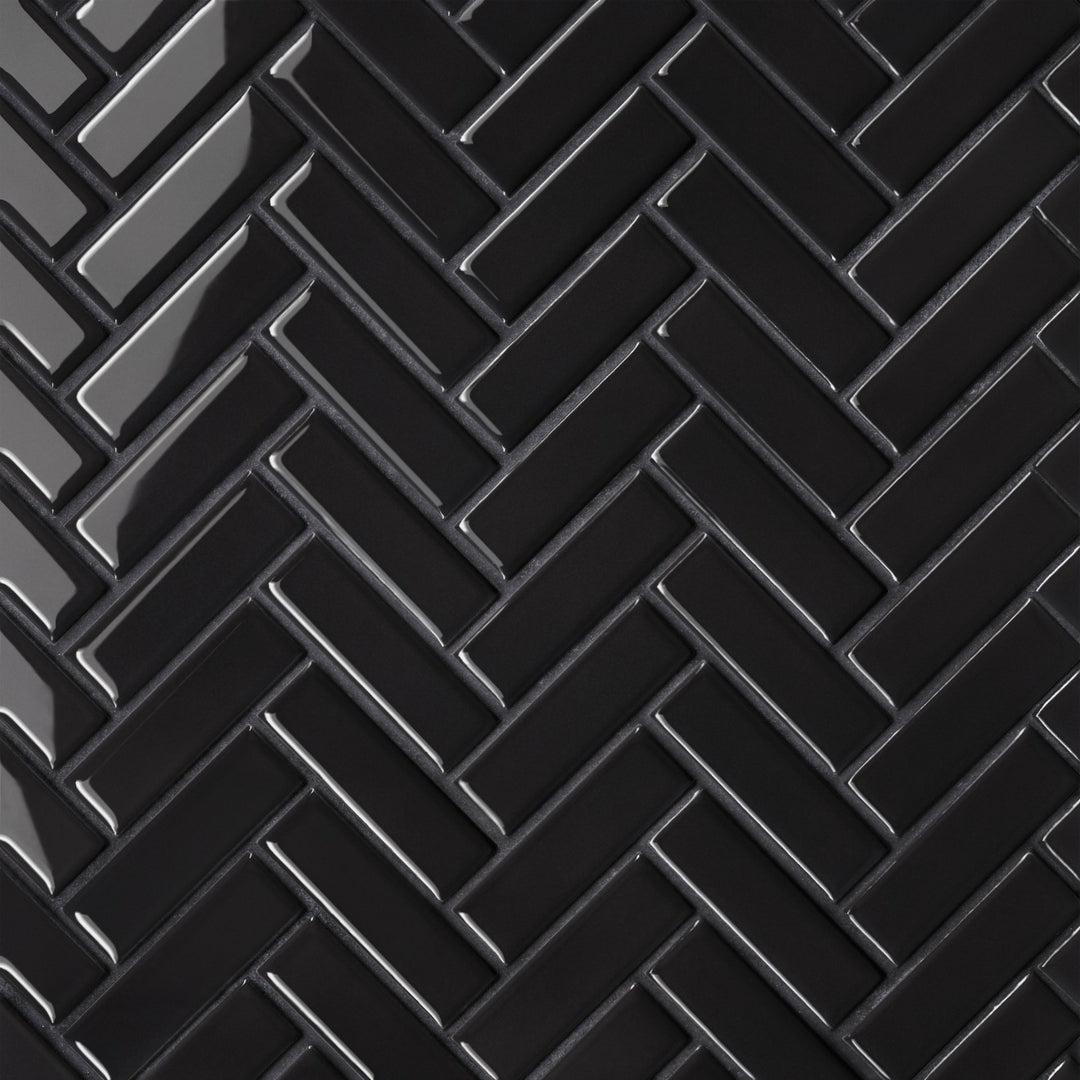 An aerial view of the Le Café Black Herringbone Gloss Porcelain Mosaic highlights its bold black shade with a reflective glaze, enhancing the distinctive herringbone design with a touch of sophistication.
