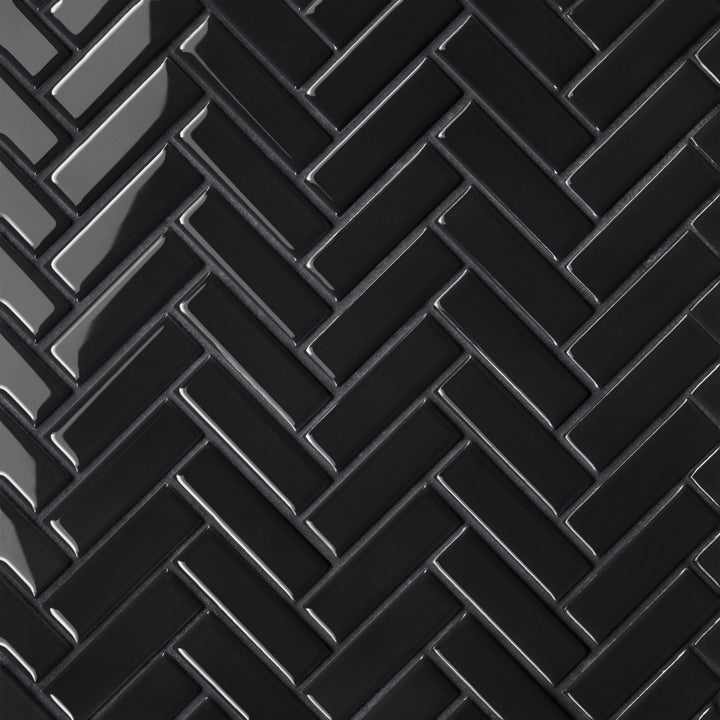 An aerial view of the Le Café Black Herringbone Gloss Porcelain Mosaic highlights its bold black shade with a reflective glaze, enhancing the distinctive herringbone design with a touch of sophistication.