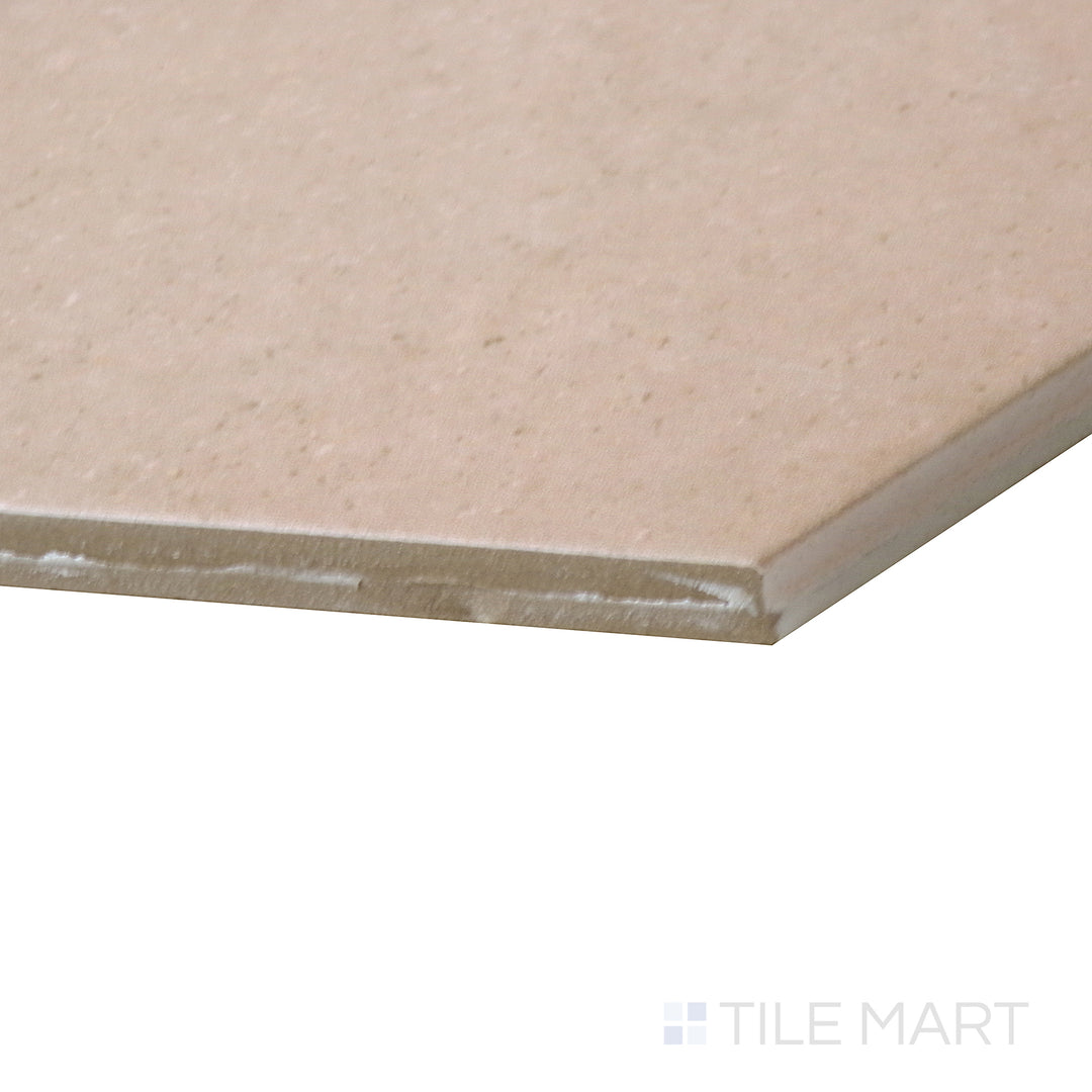 Side-angle close-up of Makoto Momoiro Blush 10" hex matte porcelain tile, capturing its soft blush tone, clean hexagonal format, and precise edge alignment.