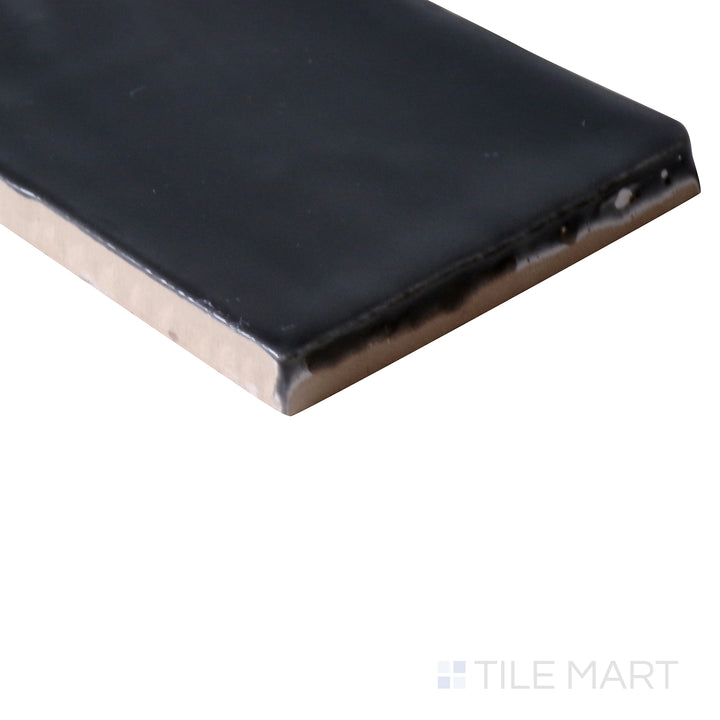 Angled perspective of Marin Black Sea 2.5x5 gloss glazed ceramic tile, featuring its deep, inky black shade, radiant glaze, and the seamless transition at the corner.