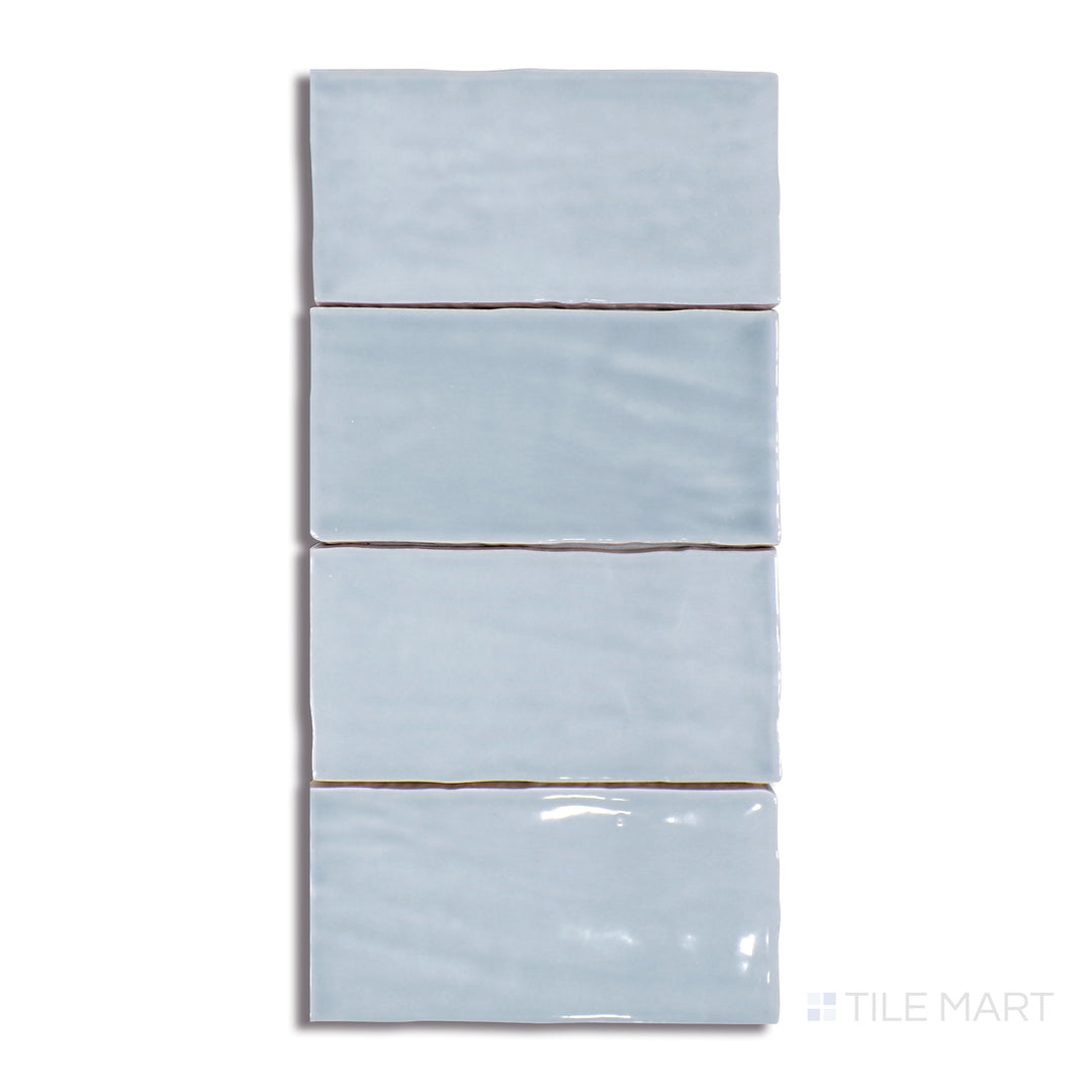 A highly detailed close-up of Marin Misty Blue 2.5X5 Gloss Glazed Ceramic tile emphasizes its soft blue-grey undertones and high-gloss finish, ideal for a tranquil aesthetic.