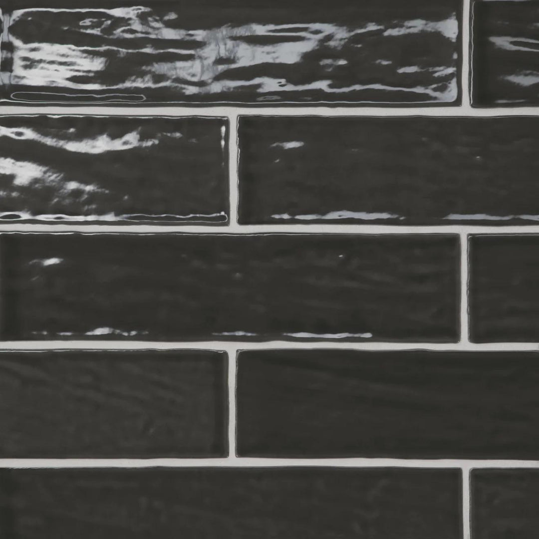 A high-contrast top-down view of the Marin Black Sea 2.5X10 Gloss Glazed Ceramic showcases its bold black tone, enhanced by a sleek gloss for a contemporary statement.