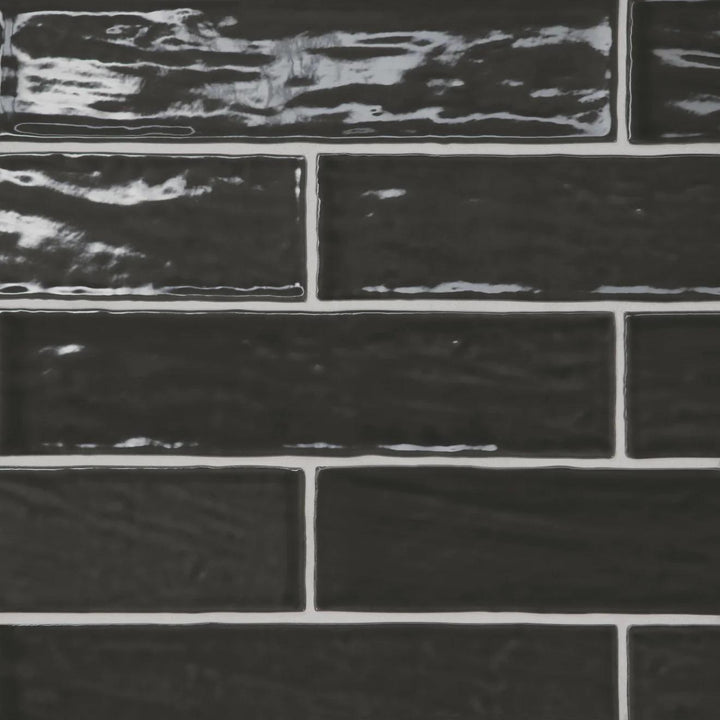 A high-contrast top-down view of the Marin Black Sea 2.5X10 Gloss Glazed Ceramic showcases its bold black tone, enhanced by a sleek gloss for a contemporary statement.