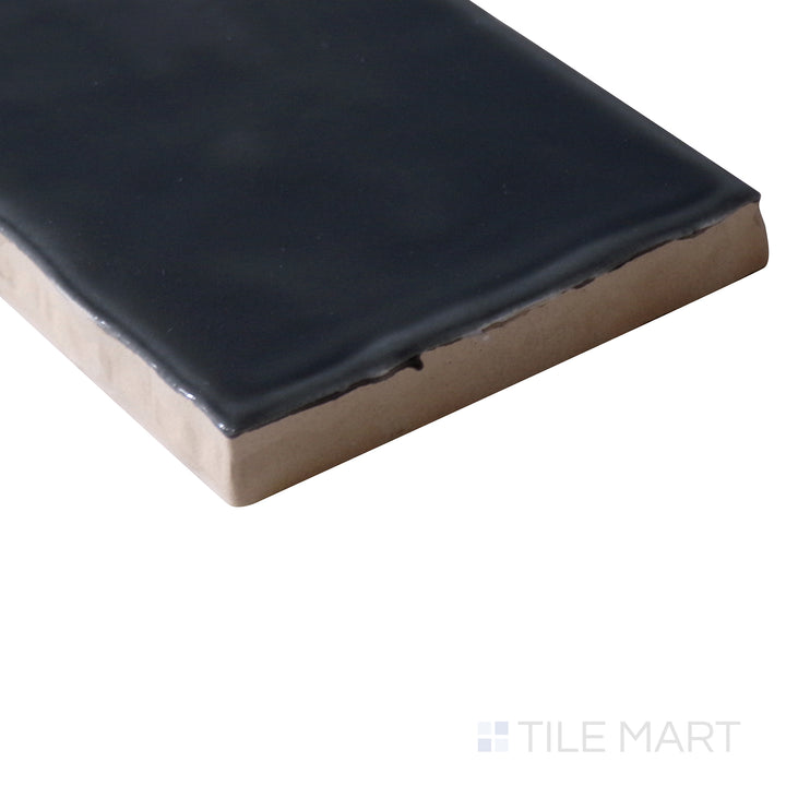 Angled close-up of Marin Black Sea 2.5x10 gloss glazed ceramic tile, featuring its bold black shade, sleek glossy finish, and smooth corner transition.