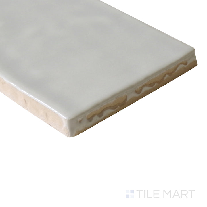 Side-angle perspective of Marin Coastal Cliff 2.5x10 gloss glazed ceramic tile, highlighting its soft beige-gray tone, glassy texture, and structured edge alignment.