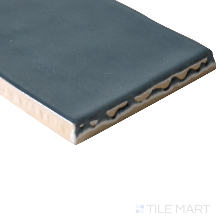 Corner-focused image of Marin Midnight Tide 2.5x10 gloss glazed ceramic tile, drawing attention to its deep navy shade, shiny finish, and seamless edge transition.