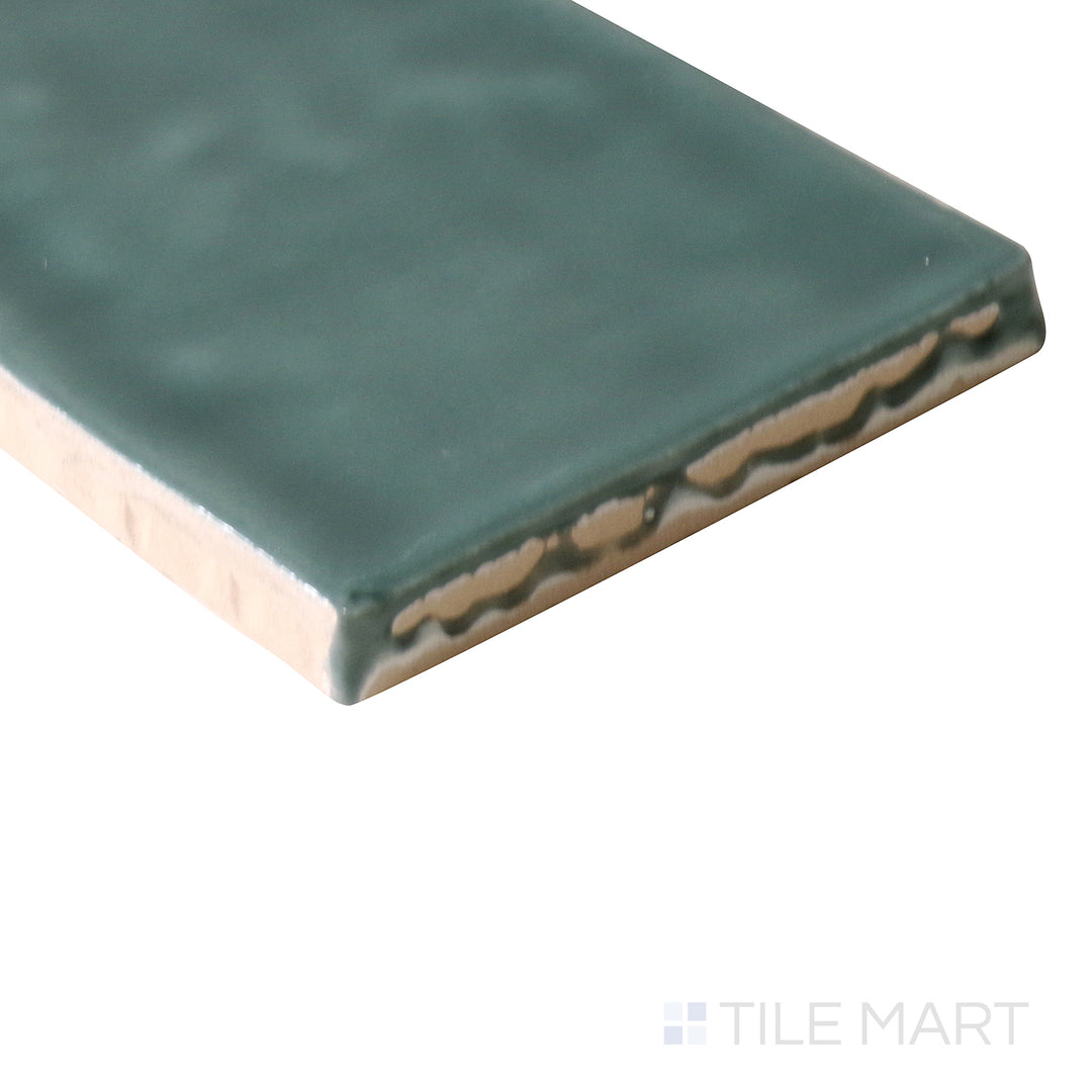 Angled shot of Marin Ocean Teal 2.5x10 gloss glazed ceramic tile, showcasing its rich teal color, reflective glaze, and how its edges meet at a structured angle.