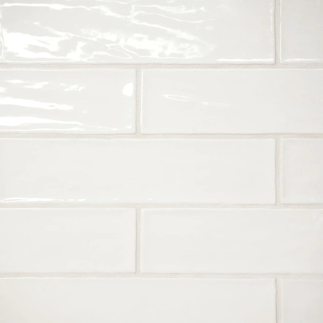 A top-down perspective of the Marin Pearl White 2.5X10 Gloss Glazed Ceramic highlights its luminous surface, bringing a clean and refined elegance to any space.