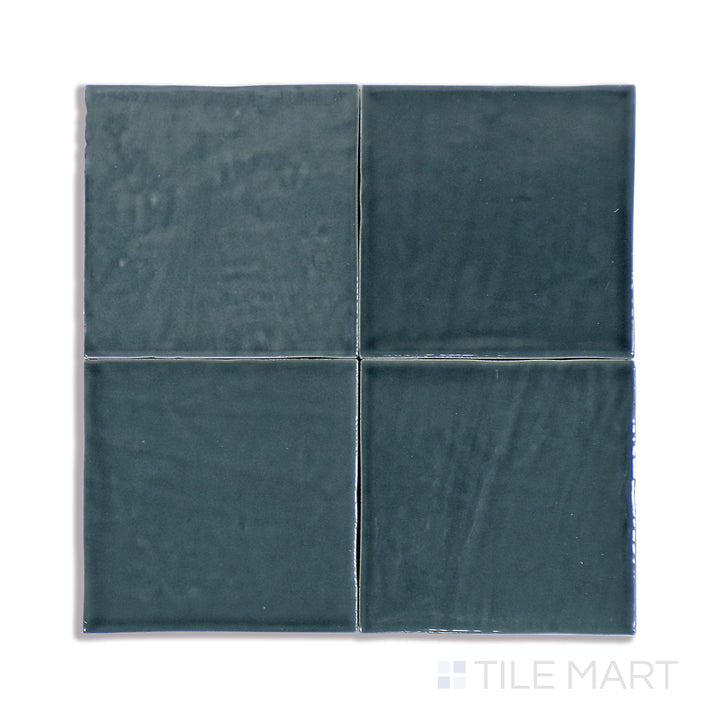 A highly detailed close-up of Marin Midnight Tide 4X4 Gloss Glazed Ceramic tile reveals its deep, rich blue color and glossy reflection, reminiscent of the night sky over water.